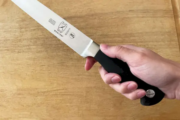Una persona sosteniendo el cuchillo de trinchar Mercer Genesis 10