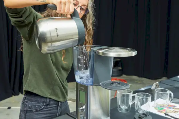 Osoba naleje vodu do tepelného kávovaru Breville Precision Brewer, 60 oz. (BDC450BSS)