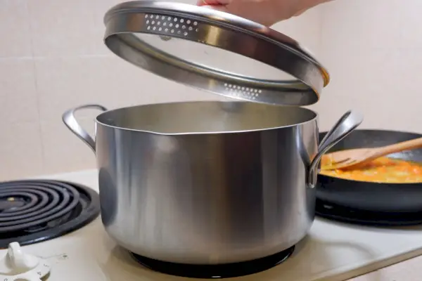 Person hält den Deckel eines GreenPan X Food 52 Five-Two Essentials 6 Quart Tri-Ply Edelstahl-Suppentopfs