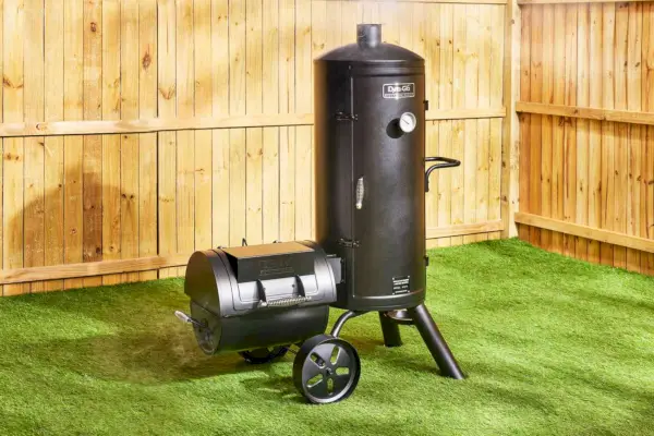 Le fumoir à charbon de bois vertical décalé Dyna-Glo Signature Series sur une terrasse