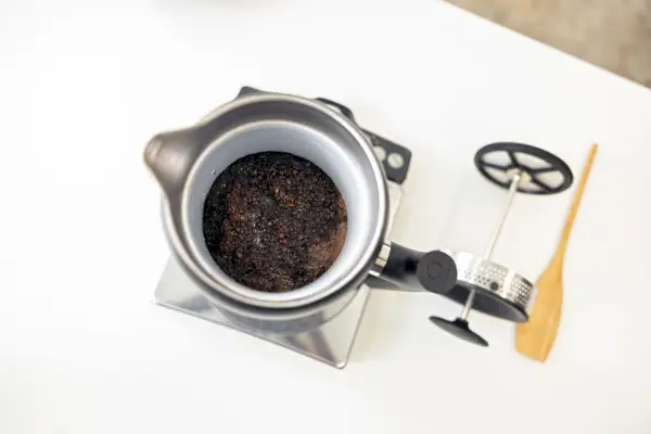 Vista aérea del café en Fellow Clara French Press exhibido sobre la encimera con una tapa cercana y una varilla agitadora