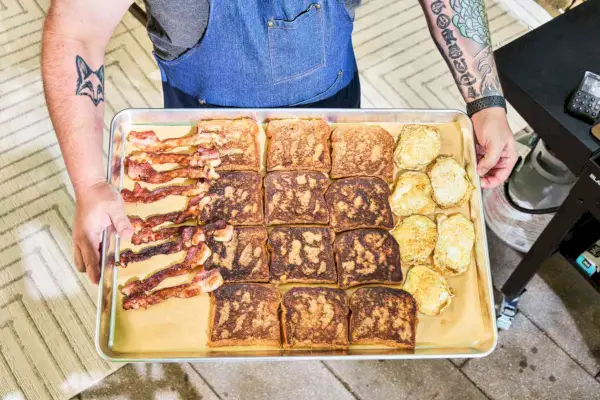 Tostadas francesas, tocino y huevos cocinados en la parrilla de gas Blackstone 1554 Cooking de 4 quemadores con superficie plana