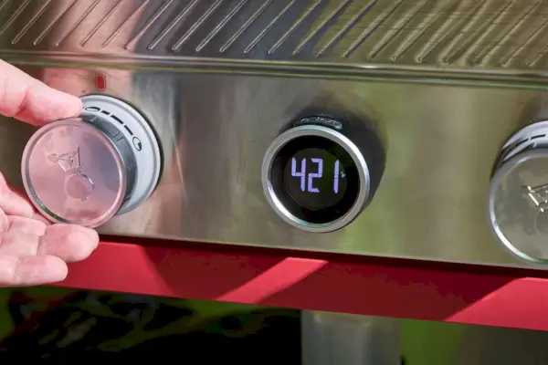 Una persona ajusta la temperatura en la plancha Weber Slate de 30 pulgadas