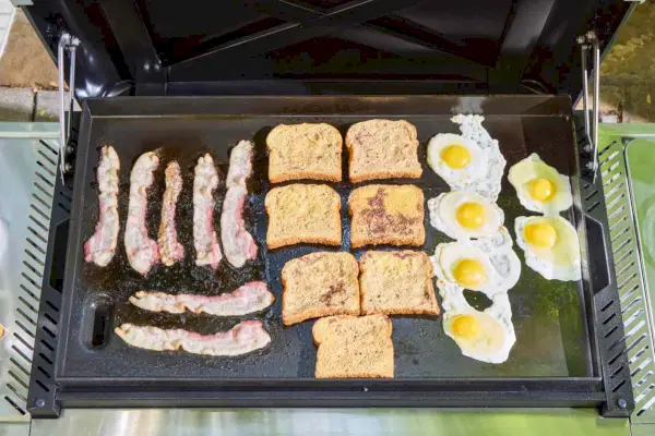 Huevos, tostadas francesas y tocino se cocinan en la plancha Weber Slate de 30 pulgadas