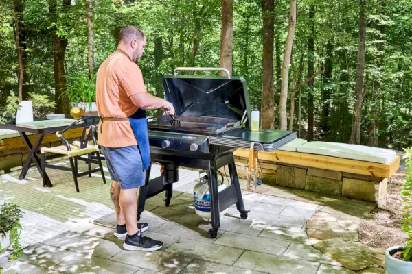 Una persona cocina en la parrilla Traeger Flatrock Flat Top Grill