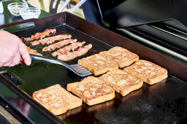 Las tostadas francesas y el tocino se cocinan en Traeger Flatrock Flat Top Grill