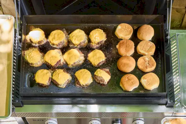 Cheeseburgers são cozidos na grelha Weber Slate de 30 polegadas