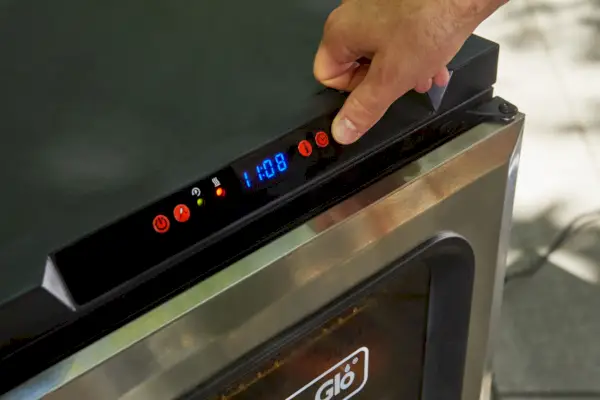 אדם לוחץ על כפתורים ב-Dyna-Glo 30-Inch Digital Bluetooth Electric Smoker, כסף (DGU732SDE-D)