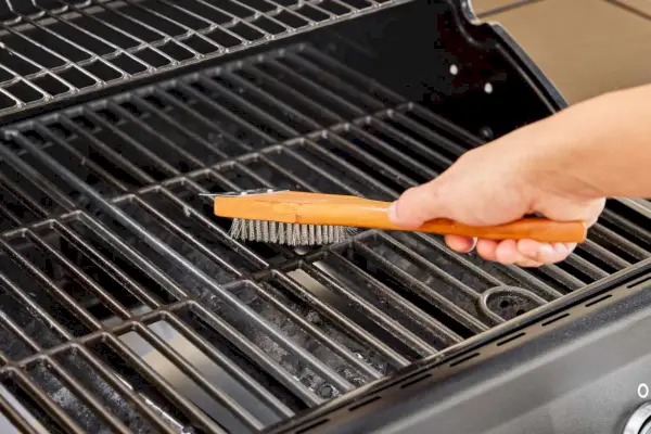 Nexgrill 4구 프로판 가스 그릴을 와이어 브러시로 손 청소하기