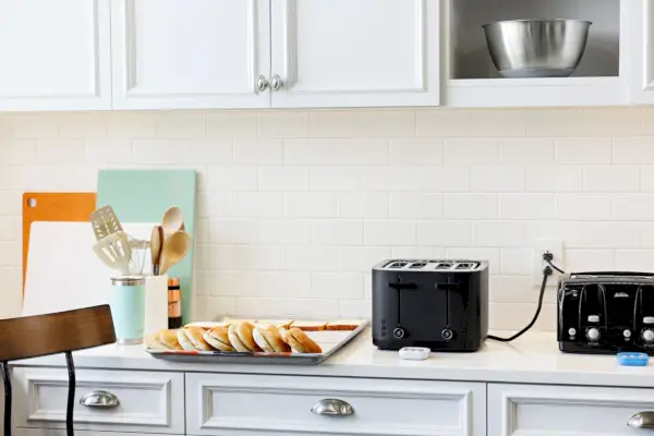 Zwilling Enfinigy Cool Touch Toaster auf einer Arbeitsplatte neben einem anderen Toaster und Brot auf einem Backblech