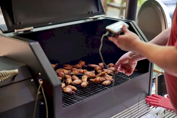 Persona che testa la griglia a pellet Yoder Smokers YS640S