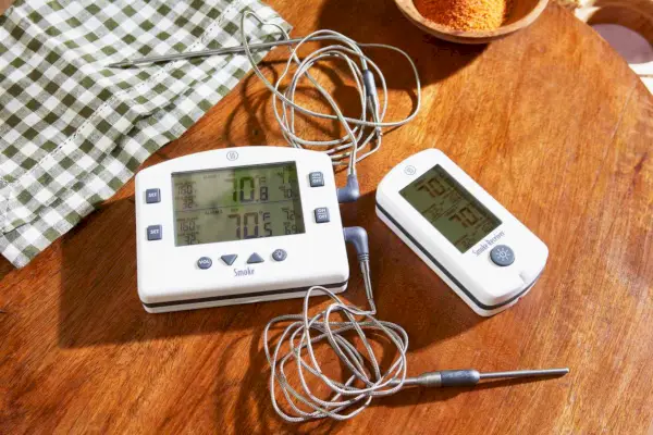 Das ThermoWorks Smoke Remote BBQ Alarm Thermometer wird auf einem Holztisch angezeigt