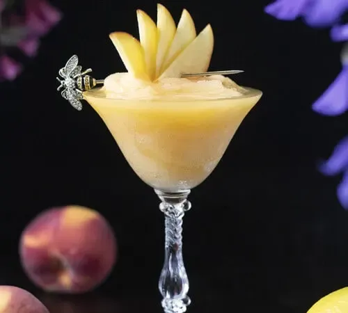 un cocktail jaune congelé dans un verre coupé vintage' title=