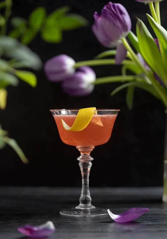 Orangencocktail mit Zitronenschale und Tulpen' loading='lazy' title=