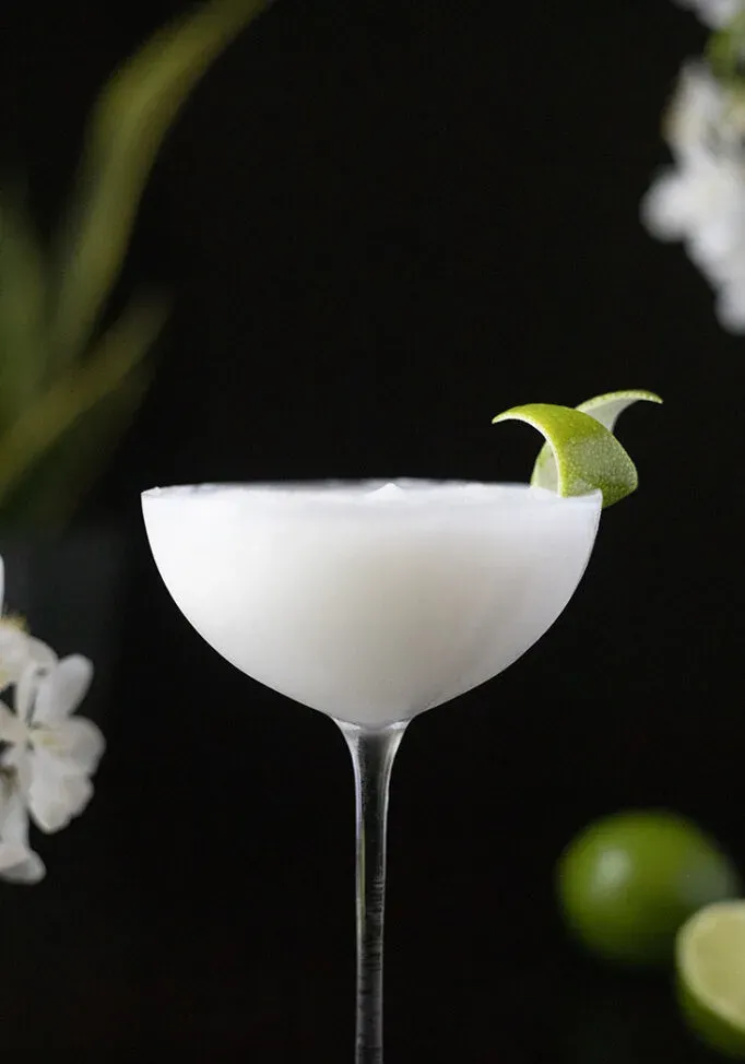 Eine herzförmige Orangenschale auf einem Cocktailspieß' title=