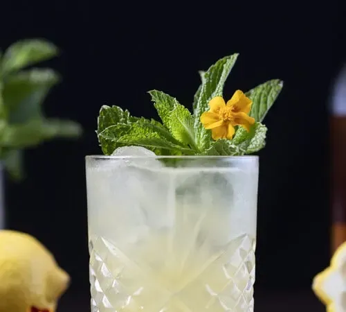 cocktail jaune à la menthe et une fleur jaune' title=