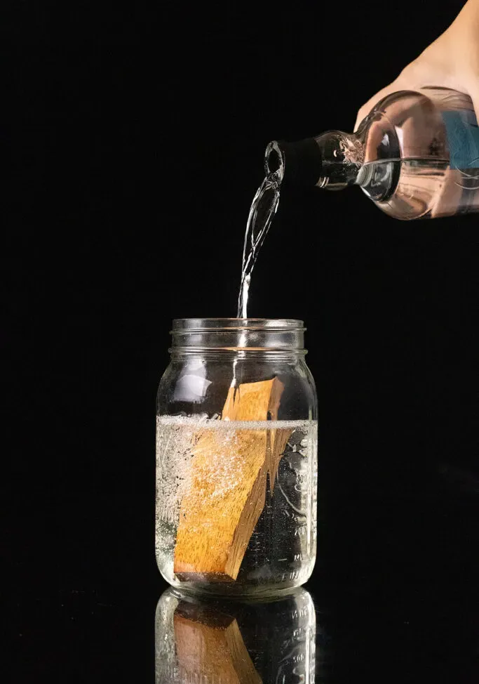 Blanco-Tequila mit einem Stück Amburana-Holz in ein Einmachglas gießen.' loading='lazy' title=