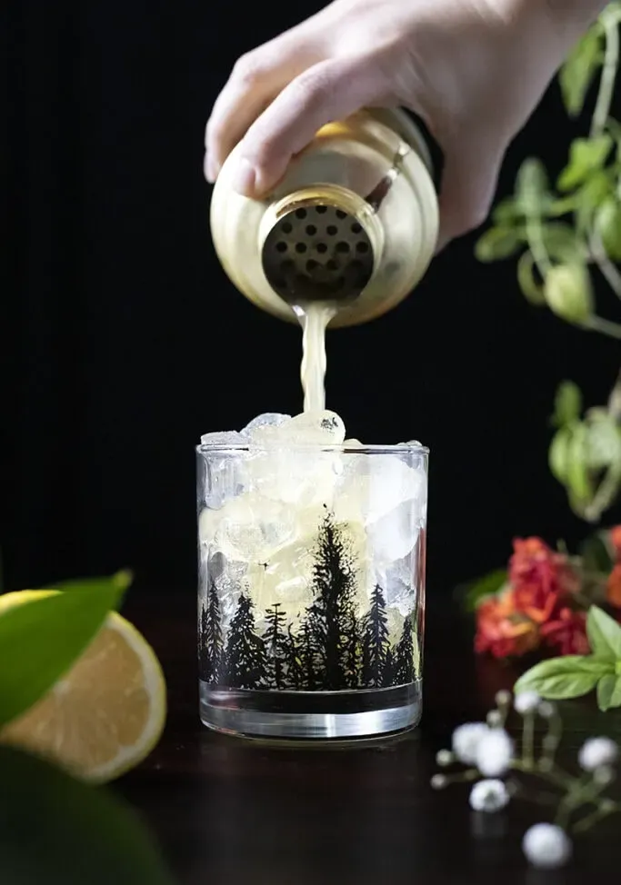 מזיגת קוקטייל משייקר לכוס סלעים מלאה בקרח' title=