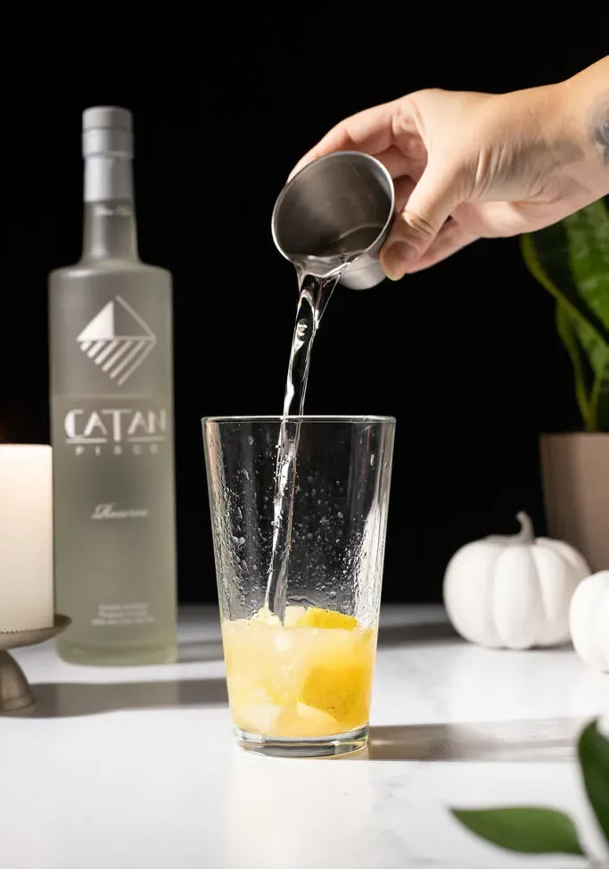 verser le pisco dans un verre à mélange avec des poires écrasées.' loading='lazy' title=