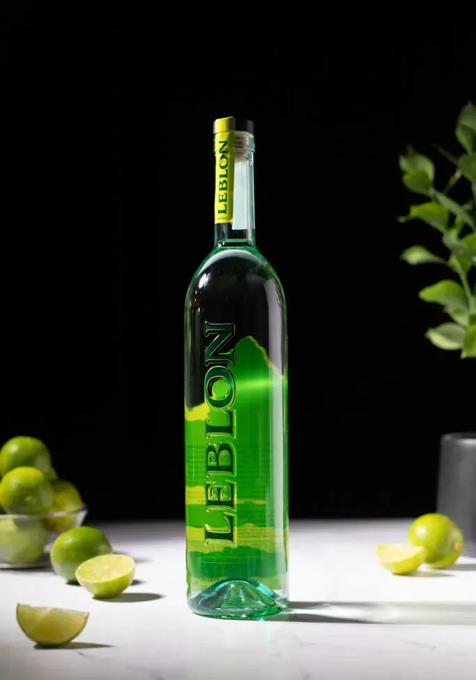 Flasche Leblon Cachaca mit grünem Schriftzug und grünem Berg auf dem Etikett.' loading='lazy' title=