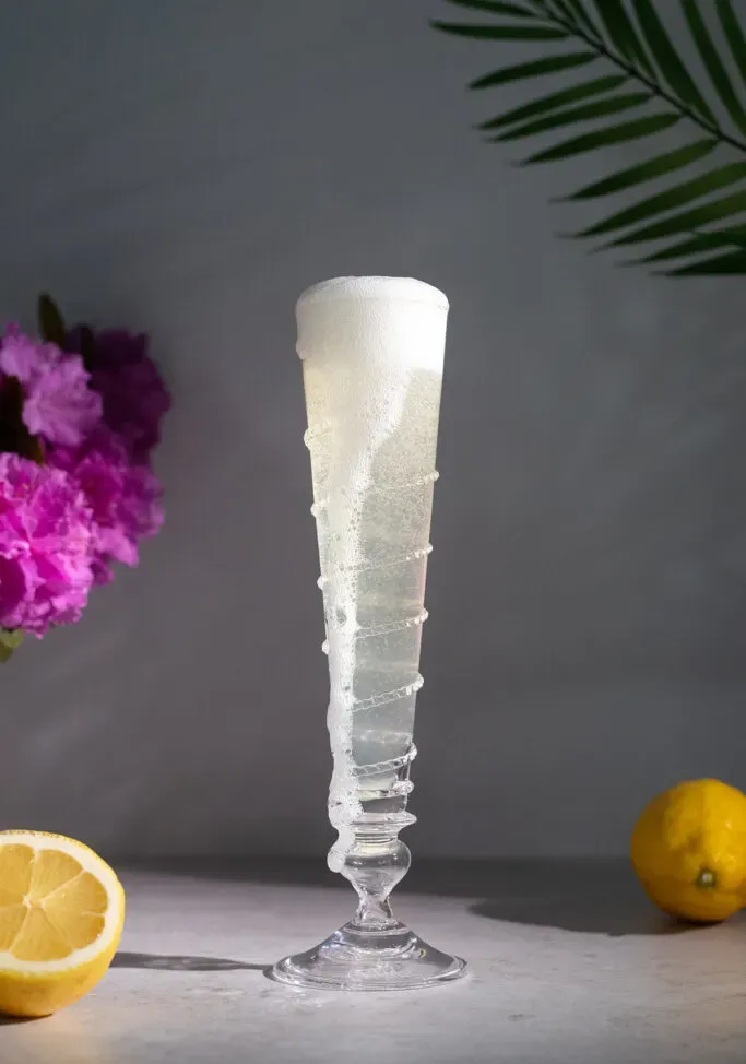 샴페인이 넘쳐흐르는 길고 슬림한 플루트 글라스.' loading='lazy' title=