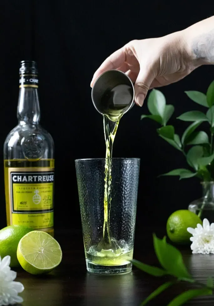 wsypując uncję żółtego Chartreuse do szklanki miksującej.' loading='lazy' title=