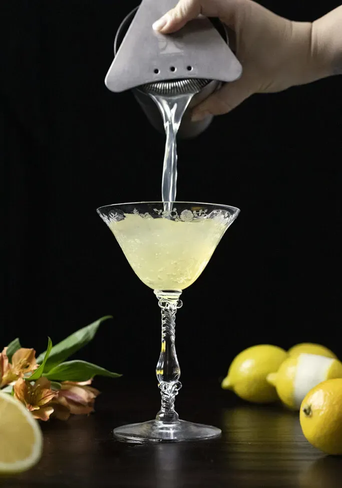 filtrer un cocktail dans un verre coupé vintage' loading='lazy' title=