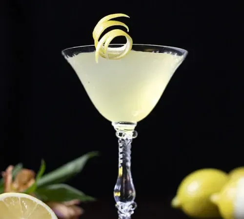 cocktail jaune dans un verre coupé vintage avec des citrons' title=