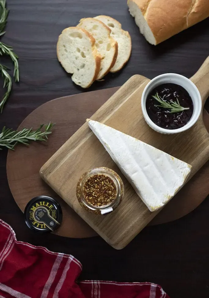 morceau de brie sur une planche à découper avec baguette et moutarde' loading='lazy' title=