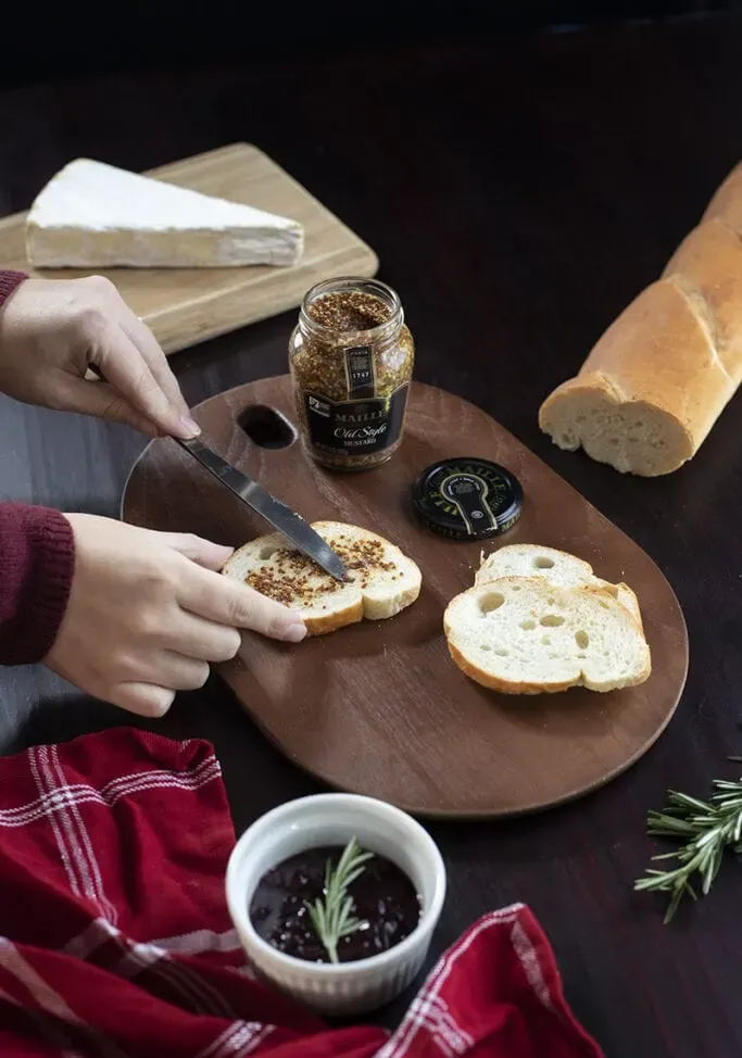 étaler de la moutarde en grains sur une baguette' title=