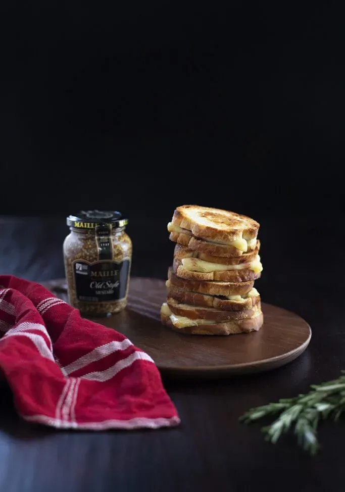 pile de sandwichs au fromage grillé miniatures sur une planche à découper' title=