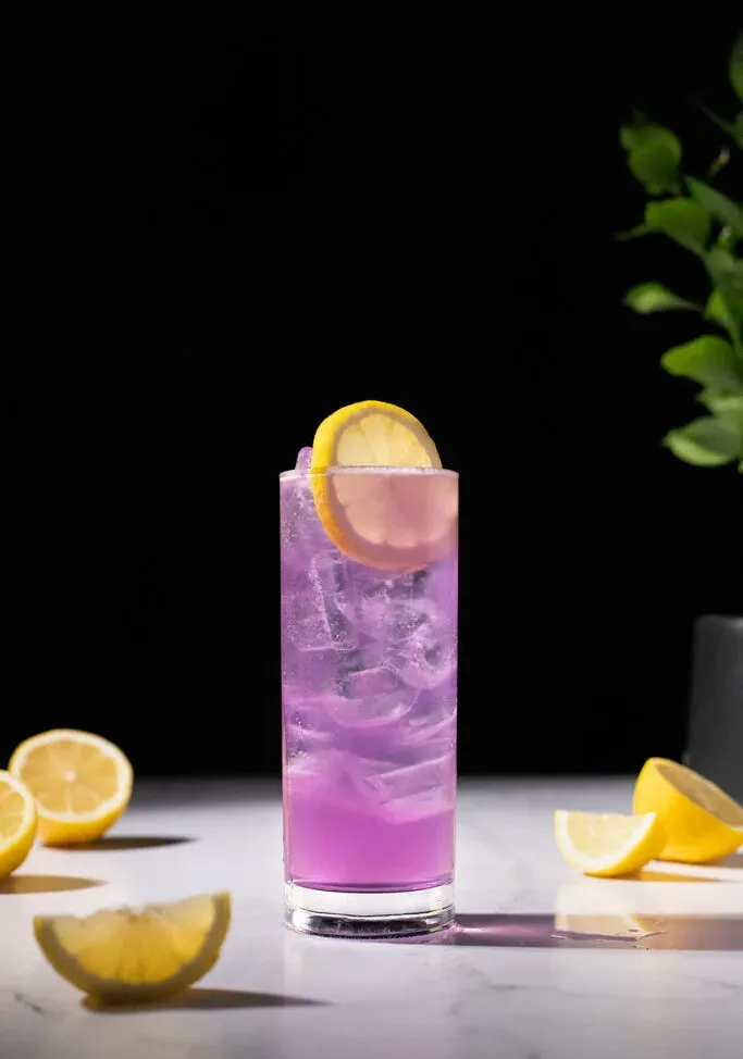 ein großes lila Getränk, garniert mit einer Zitronenscheibe.' title=