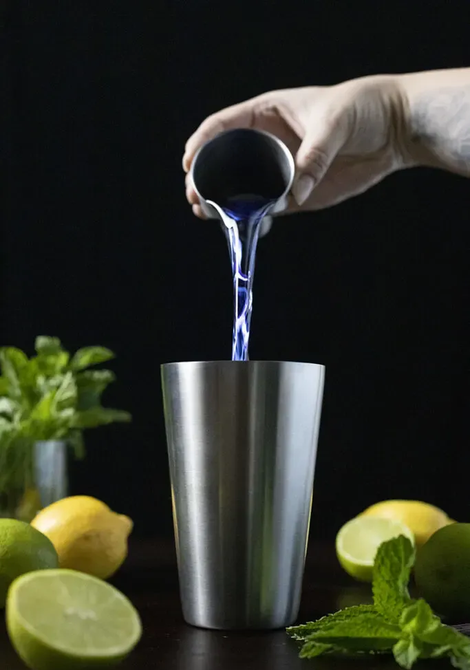 verser du gin bleu dans un shaker' loading='lazy' title=
