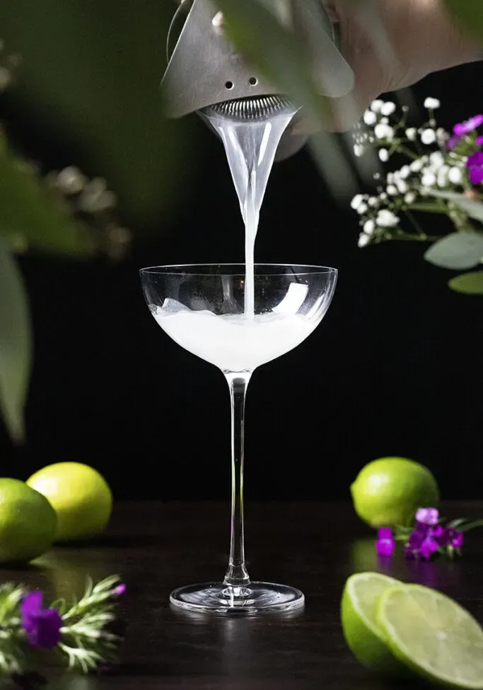 nalévání koktejlu do sklenice kupé' loading='lazy' title=