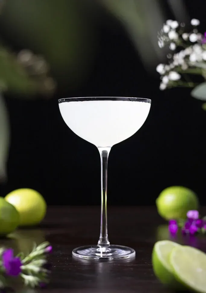 bílý koktejl na stole s limetkami' title=