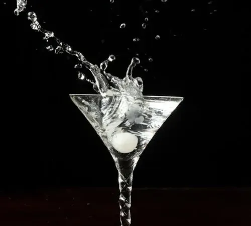 una cipolla da cocktail spruzzata in un martini' title=