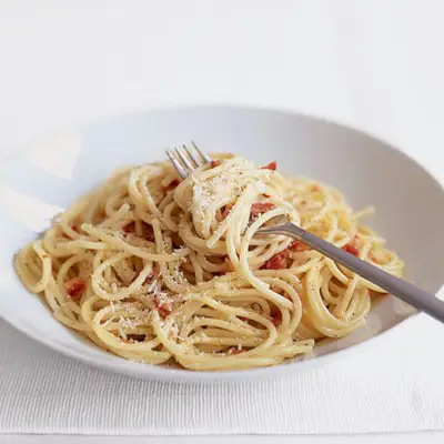 Detailný pohľad na porciu krémových špagiet carbonara v bielej miske.