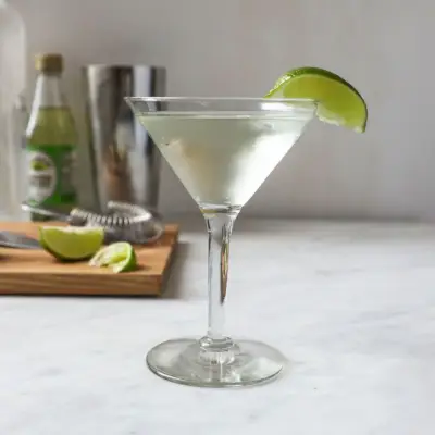 Ein Wodka-Gimlet, serviert in einem Martini-Glas und garniert mit einer Limettenscheibe.