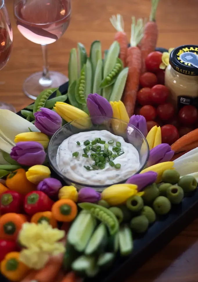 Prato crudites de vegetais frescos da primavera com mostarda cremosa e molho de ervas, decorado com cebolinha' title=