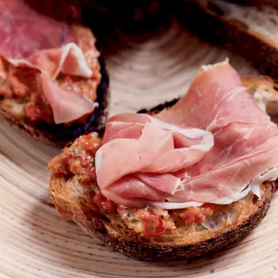 Bruschetta de jamón, tomate y aceitunas