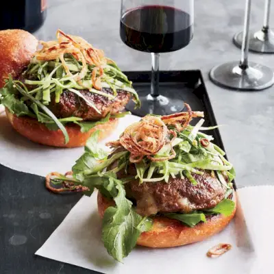 Hamburger ripieni di formaggio cheddar con insalata in salamoia e scalogno fritto