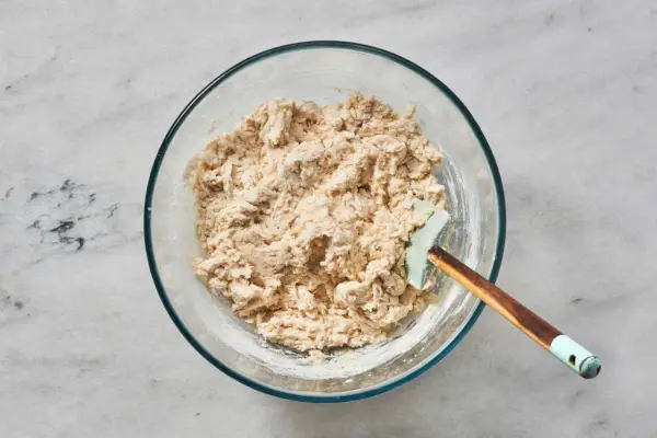 Un tazón de masa suelta hecha con leche, yogur, mezcla de agua, levadura y mezcla de harina y bicarbonato de sodio.