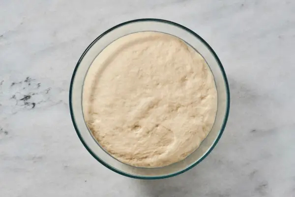Un bol grande de vidrio engrasado con masa cocida.