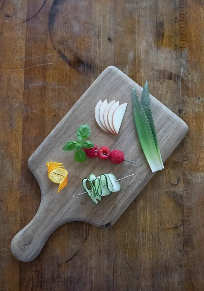 widok z góry na deskę do krojenia na starym drewnianym stole z pięcioma złożonymi dodatkami koktajlowymi' loading='lazy' title=