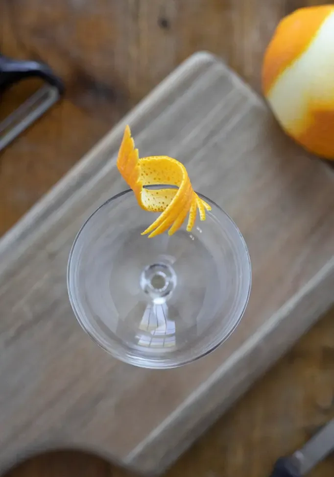 widok z góry na kieliszek coupe z fantazyjnym, kolczastym pomarańczowym akcentem na krawędzi' title=