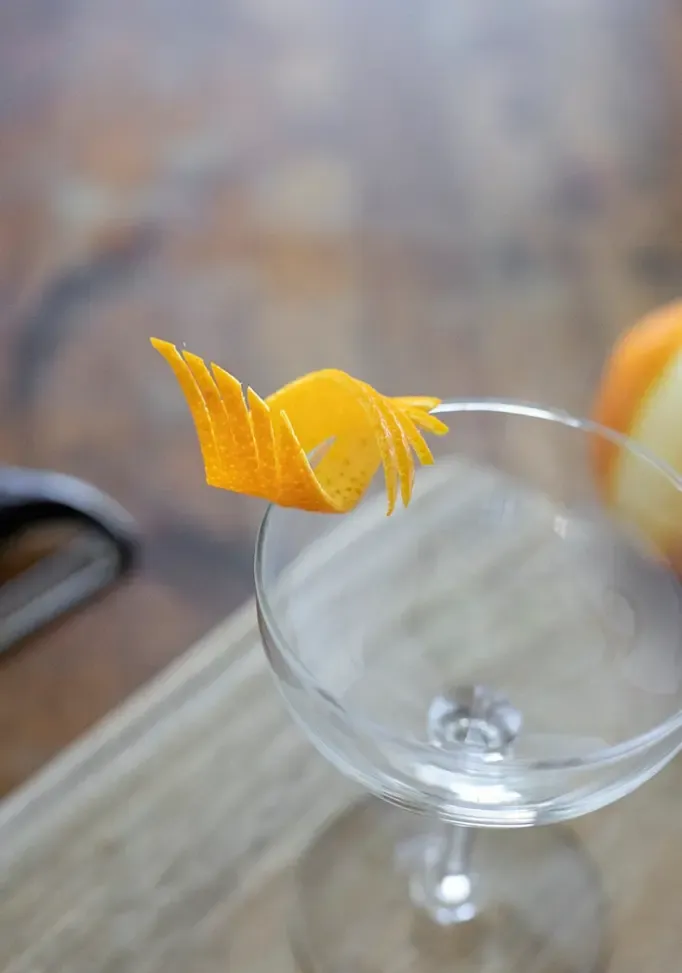 fantazyjnie wycięty pomarańczowy akcent na krawędzi kieliszka coupe' title=