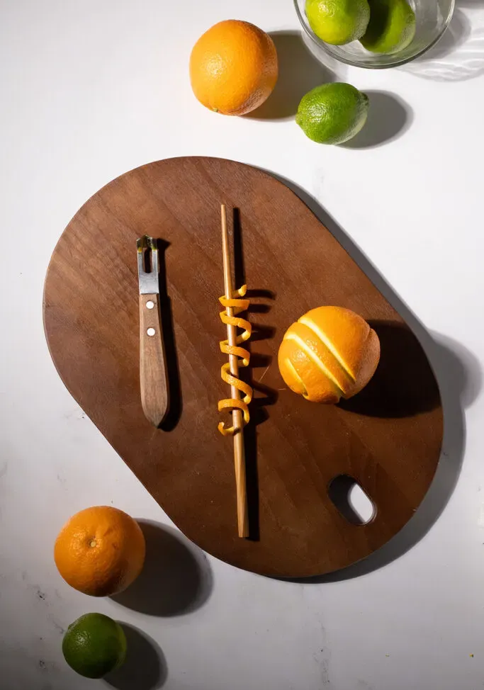 un trozo largo de cáscara de naranja envuelto alrededor de un palillo de madera.' title=