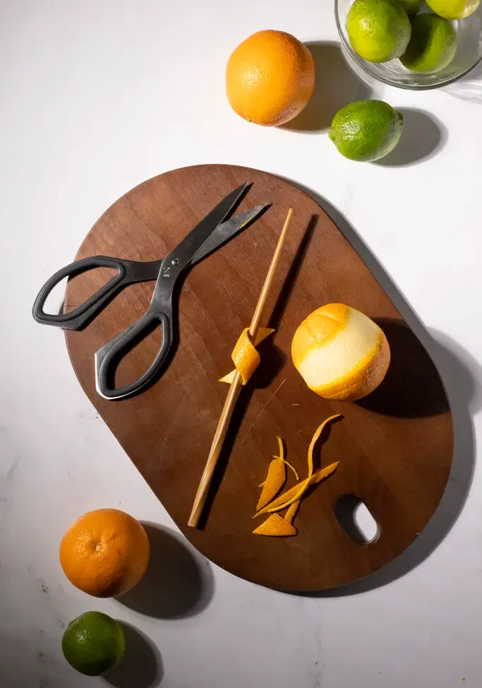 una cáscara de naranja envuelta alrededor de un palillo de madera para darle un giro.' title=