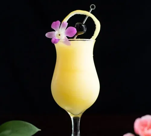 coquetel congelado amarelo em um copo poco grande' title=