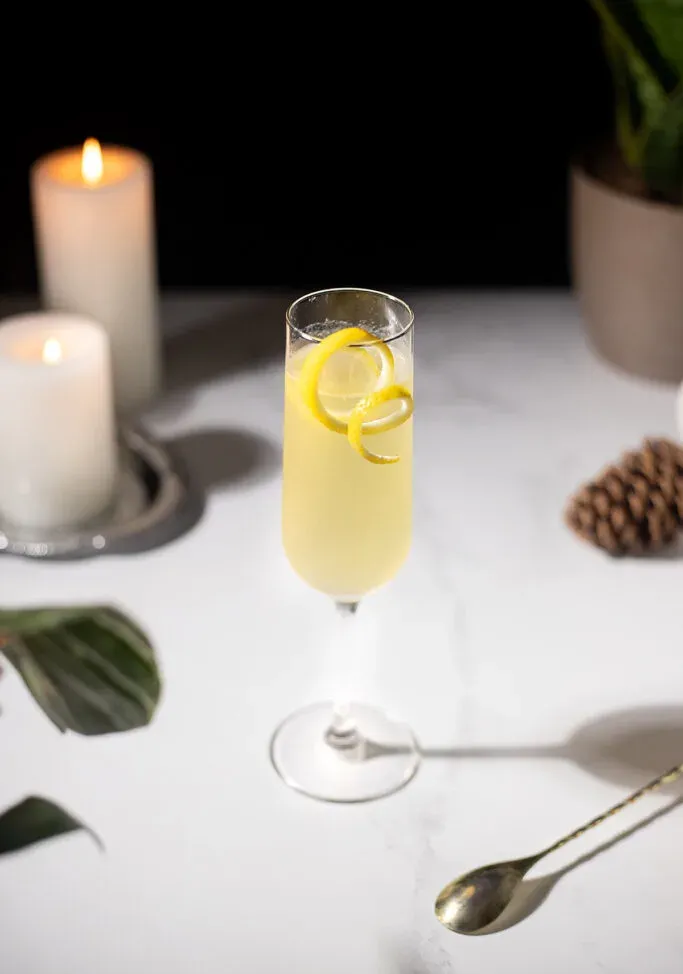 ein weißer Tisch mit Kerzen und einem gelben Champagnercocktail.' loading='lazy' title=